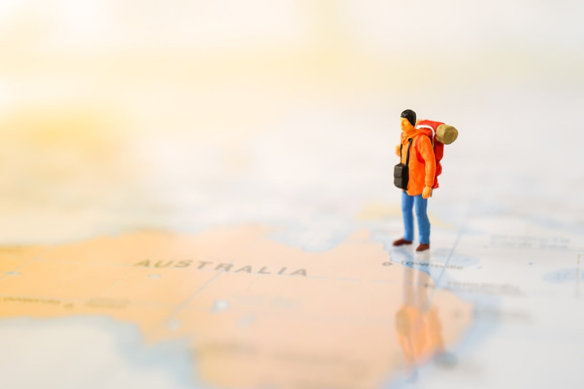 一个孤独的背包客在澳大利亚旅行，被描绘成地图上的小雕像。