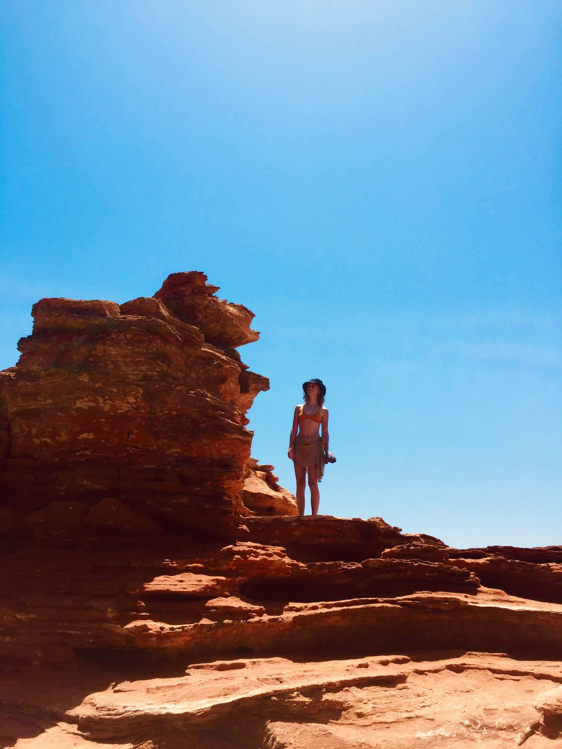 一个女孩站在澳大利亚西部布鲁姆的红色岩石上