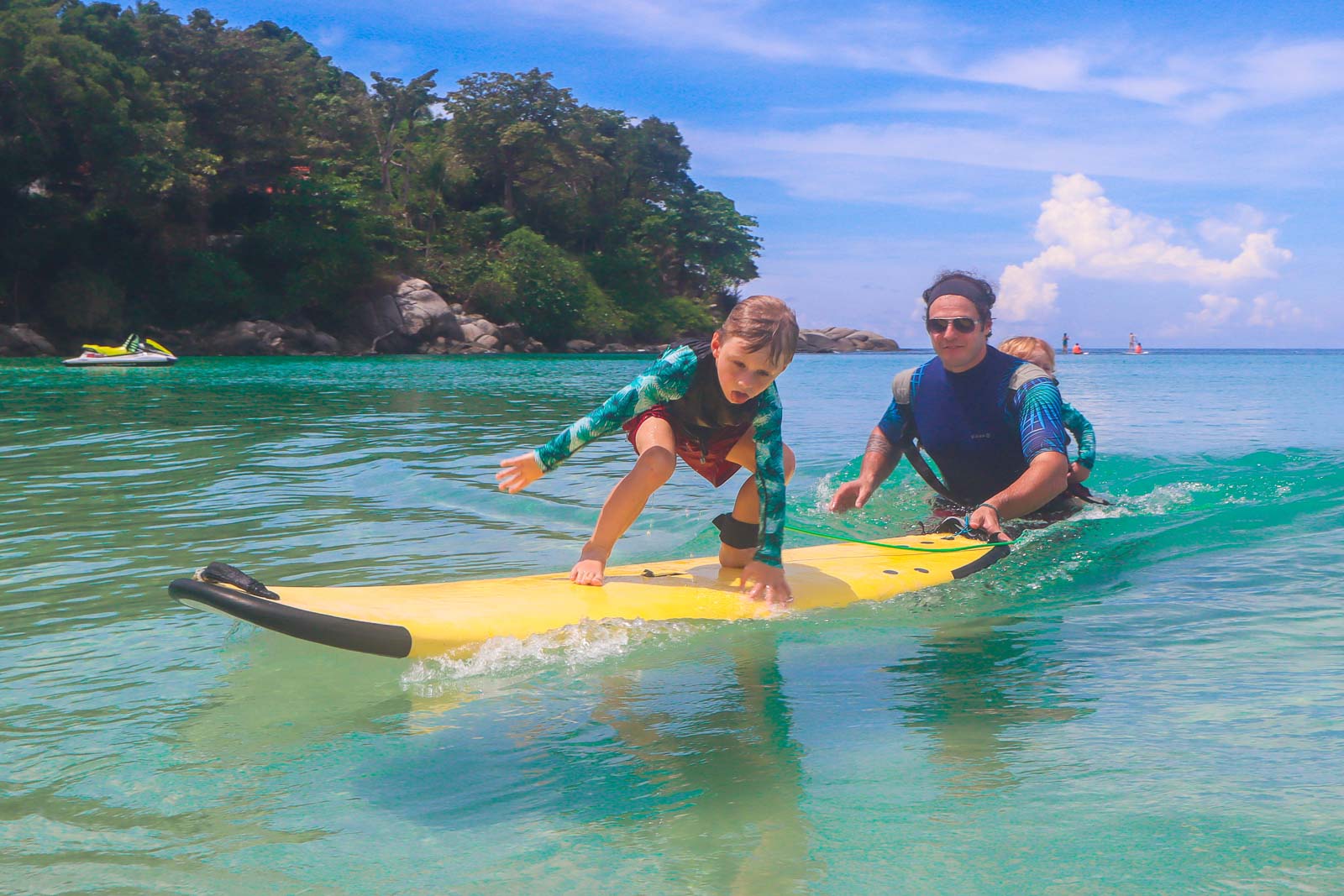 在泰国，孩子们正在蓝绿色的水面上学习冲浪